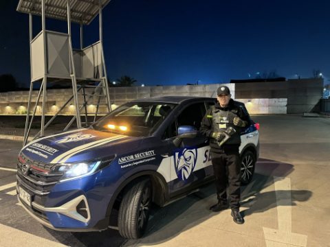 Guardia de ASCOR Security junto al vehículo institucional durante un turno nocturno