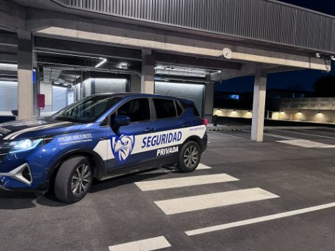 Vehículo institucional de ASCOR Security estacionado bajo un edificio, de noche