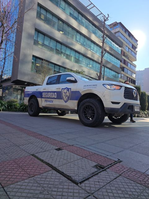 Camioneta institucional de ASCOR Security estacionada frente a un edificio de oficinas